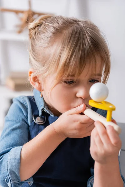 Child using respiratory muscle trainer in classroom — Stock Photo