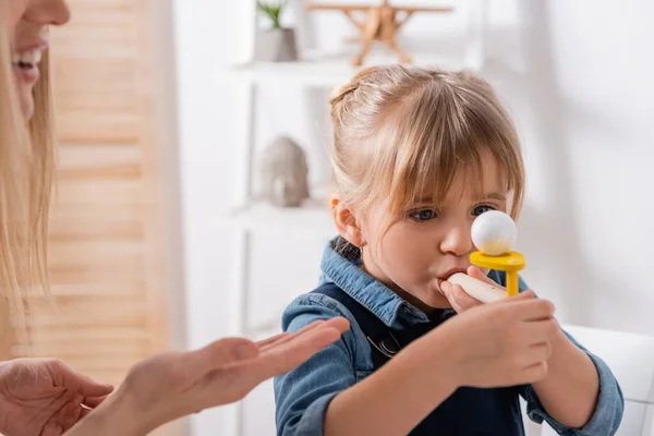 Speech therapist indicando una ragazza con allenatore muscolare respiratorio in classe — Foto stock