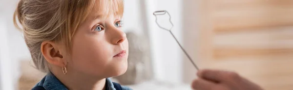 Pupil looking away near speech therapist with logopedic probe in classroom, banner — Stock Photo