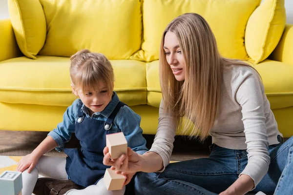 Mädchen sitzt neben Logopädin mit Holzklotz im Sprechzimmer — Stockfoto