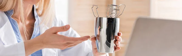 Cropped view of speech therapist pointing at tools near laptop in consulting room, banner — Stock Photo