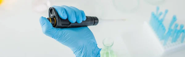 Vue recadrée du scientifique en gant de latex bleu à l'aide de micropipette en laboratoire, bannière — Photo de stock