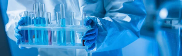 Vista ritagliata dello scienziato in guanti di lattice in possesso di provette in laboratorio, banner — Foto stock
