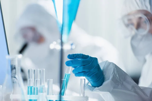 Bioingeniero borroso en guante de látex que trabaja con tubos de ensayo en laboratorio — Stock Photo