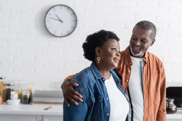 Happy and senior african american man hugging wife — Stock Photo