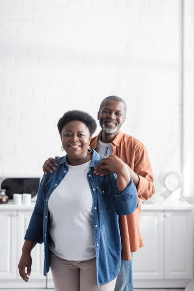 Glücklich und senior afrikanisch amerikanisch mann umarmt fröhliche frau — Stockfoto