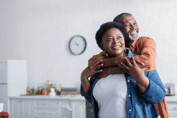Feliz e sênior africano americano homem abraçando sorrindo esposa — Fotografia de Stock