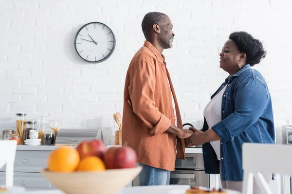 Happy and senior african american man holding hands with smiling wife — Stock Photo