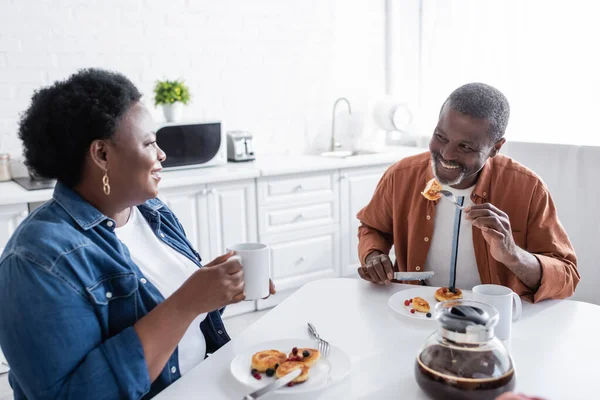 Alegre y senior africano americano pareja teniendo desayuno - foto de stock