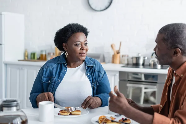 Старшая африканская американская пара разговаривает за завтраком — стоковое фото