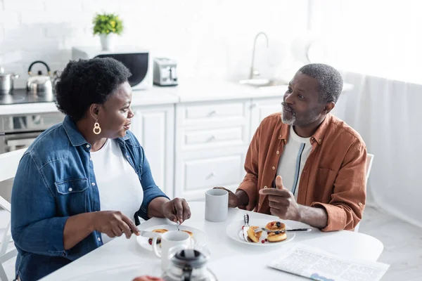 Senior couple afro-américain parler pendant le petit déjeuner dans la cuisine — Photo de stock