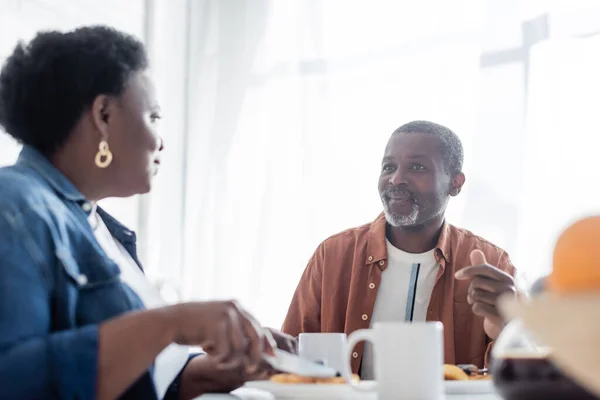 Ältere afrikanisch-amerikanische Mann im Gespräch mit Frau während des Frühstücks — Stockfoto