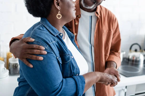 Cropped view of happy senior african american man holding hand of wife — Stock Photo