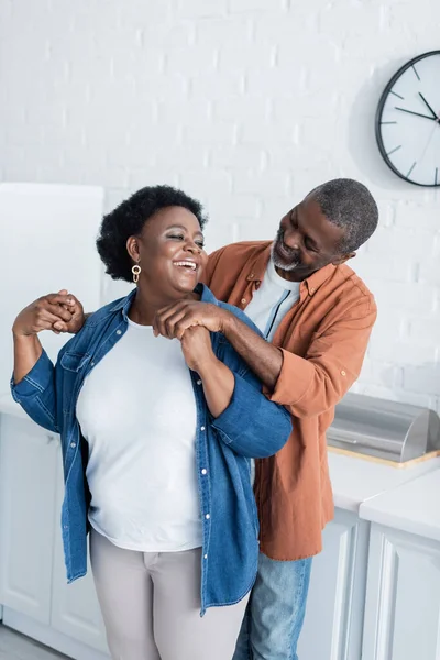 Happy senior african american man holding hands of smiling wife — Stock Photo