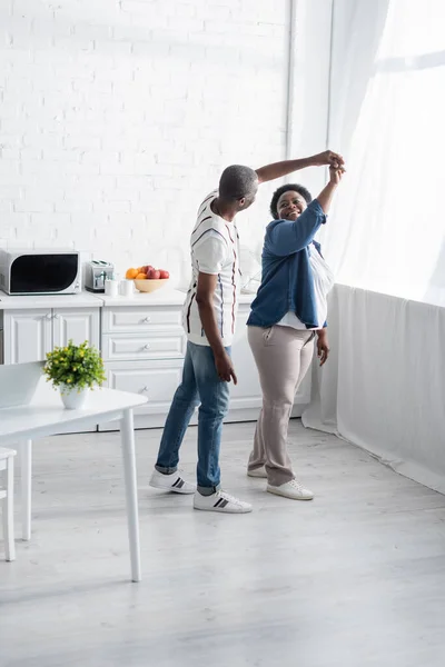 Comprimento total de feliz casal africano sênior dançando na cozinha — Fotografia de Stock