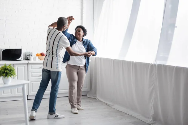 Volle Länge der fröhlichen Senior afrikanisch-amerikanischen Paar tanzen in der Küche — Stockfoto