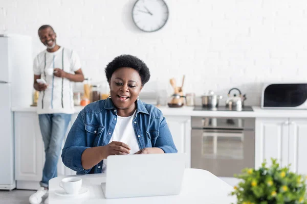 Mulher americana africana feliz olhando para laptop durante chamada de vídeo — Fotografia de Stock