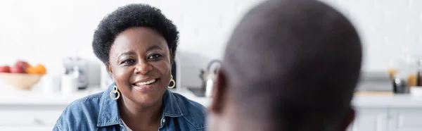 Feliz sénior afroamericano mujer mirando marido, bandera - foto de stock