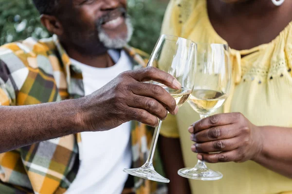 Cropped view of senior african american couple clinking glasses of wine — Stock Photo