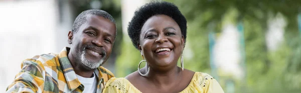 Усміхнена і старша афроамериканська пара дивиться на камеру, банер — стокове фото