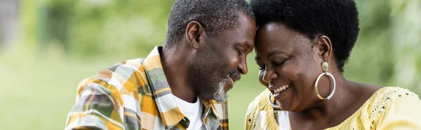 Tierna y mayor pareja afroamericana con los ojos cerrados, pancarta - foto de stock