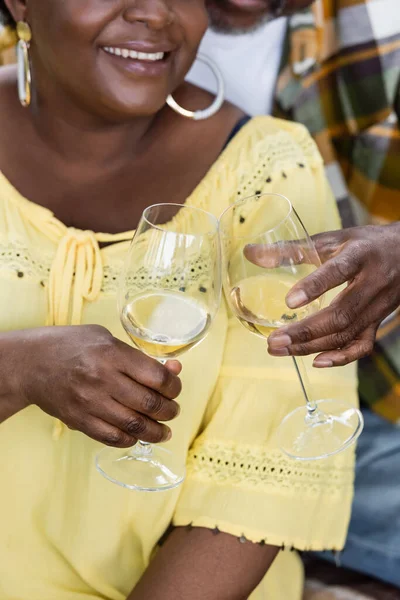 Vue recadrée de joyeux et senior couple afro-américain cliquetis verres de vin — Photo de stock