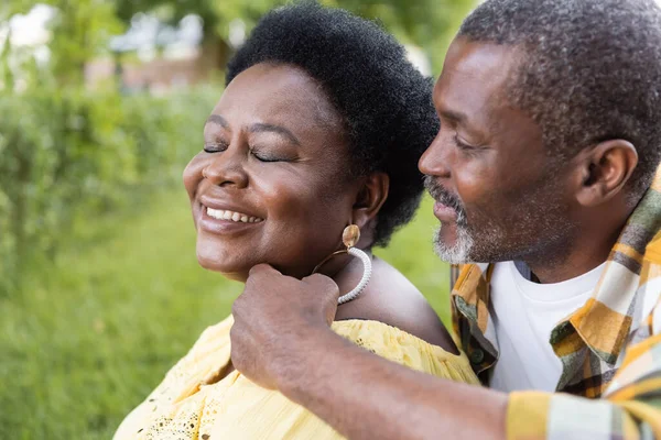 Retrato de alegre y mayor pareja afroamericana con los ojos cerrados - foto de stock
