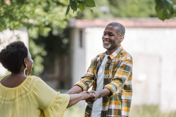 Senior coppia afroamericana sorridente e ballando nel parco — Foto stock