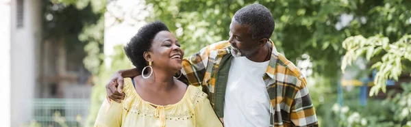 Felice coppia afroamericana anziana passeggiando nel parco, striscione — Foto stock