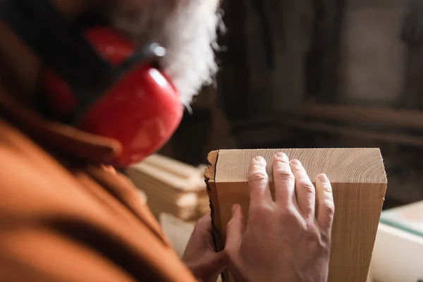 Cropped view of blurred furniture designer checking board in workshop — Stock Photo