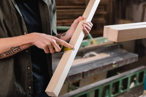 Partial view of furniture designer measuring plant with tape measure — Stock Photo