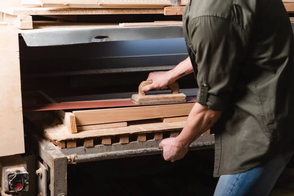 Partial view of carpenter polishing board on sander machine — Stock Photo