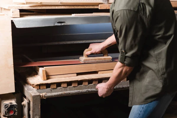 Partial view of carpenter polishing board on sander machine — Stock Photo