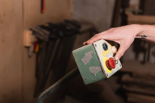 Partial view of carpenter pushing button on control relay — Stock Photo