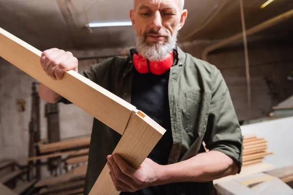 Blurred furniture designer making corner from wooden planks — Stock Photo