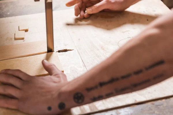 Cropped view of blurred joiner cutting plank with band saw — Stock Photo