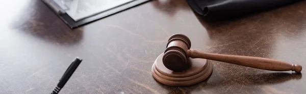 Office desk with wooden judge gavel, banner — Stock Photo