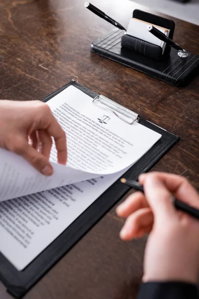 Partial view of prosecutor with pen near lawsuit on clipboard — Fotografia de Stock