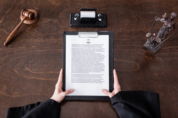 Top view of clipboard with verdict near cropped judge, gavel and themis statue - foto de stock