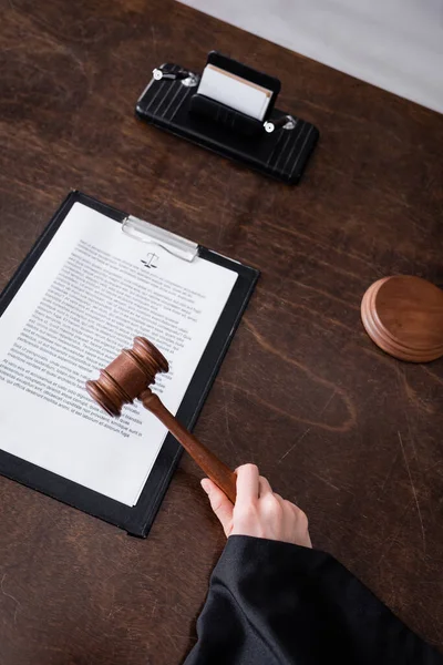 Partial view of judge holding wooden gavel near clipboard with lawsuit — Stock Photo