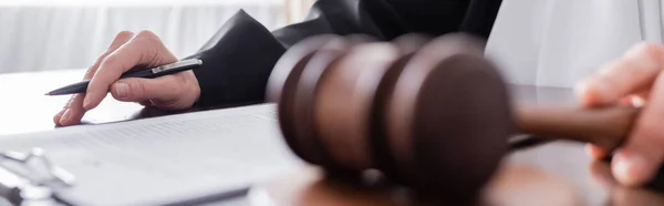 Cropped view of judge with pen and gavel at workplace, banner — Fotografia de Stock