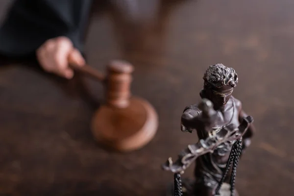 Selective focus of themis statue near cropped judge with gavel on blurred background — Fotografia de Stock