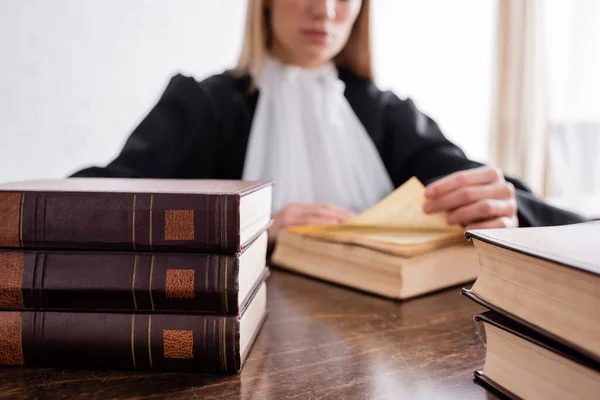 Selective focus of book near cropped prosecutor reading on blurred background — Stock Photo