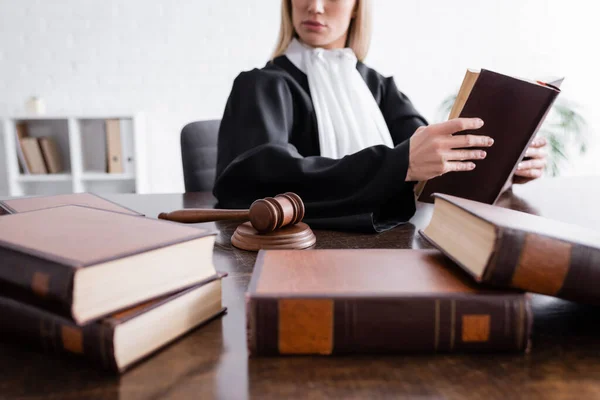 Collection of blurred books near cropped prosecutor and wooden gavel — Photo de stock