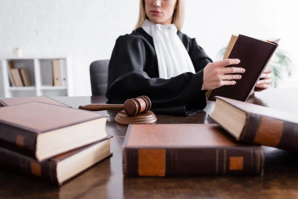 Collection of blurred books near cropped prosecutor and wooden gavel — Fotografia de Stock