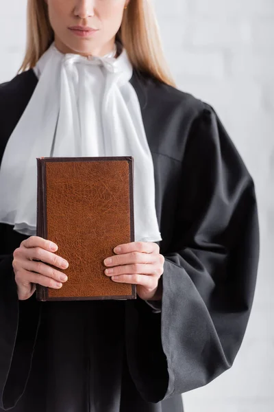 Partial view of prosecutor in mantle holding book — Photo de stock