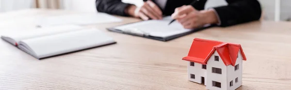 Selective focus of house model near cropped notary on blurred background, banner — Fotografia de Stock