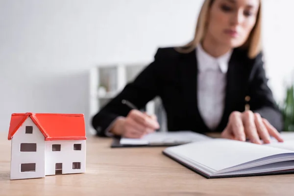 Selective focus of house model near blurred notary on background — Fotografia de Stock