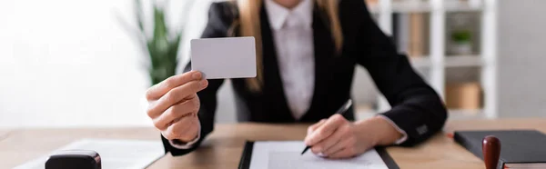 Vista recortada del notario que sostiene la tarjeta de visita en blanco, bandera — Stock Photo