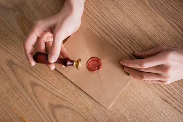 Teilansicht eines Rechtsanwalts mit Stempel in der Nähe eines mit Wachs versiegelten Briefumschlags aus Bastelpapier — Stockfoto